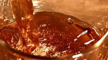 Siyah çay fincana dökülür. 1000 fps 'de yüksek hızlı bir kamerayla çekildi. Yüksek kaliteli FullHD görüntüler