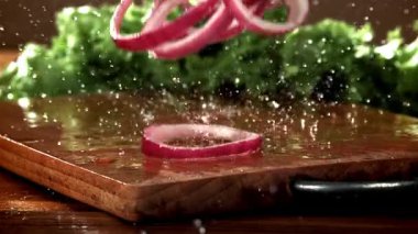 Doğranmış soğan kesme tahtasına düşer. 1000 fps 'de yüksek hızlı bir kamerayla çekildi. Yüksek kaliteli FullHD görüntüler