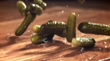 Salatalık turşusu ahşap bir masaya düşer. 1000 fps 'de yüksek hızlı bir kamerayla çekildi. Yüksek kaliteli FullHD görüntüler