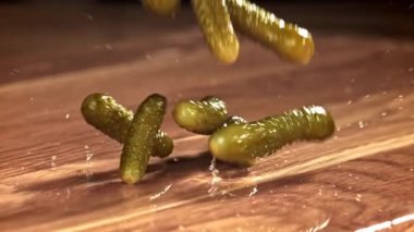 Salatalık turşusu ahşap bir masaya düşer. 1000 fps 'de yüksek hızlı bir kamerayla çekildi. Yüksek kaliteli FullHD görüntüler