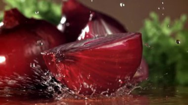 Soğan ıslak bir kesme tahtasına düşer. 1000 fps 'de yüksek hızlı bir kamerayla çekildi. Yüksek kaliteli FullHD görüntüler