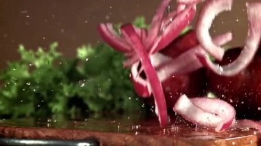 Doğranmış soğan kesme tahtasına düşer. 1000 fps 'de yüksek hızlı bir kamerayla çekildi. Yüksek kaliteli FullHD görüntüler