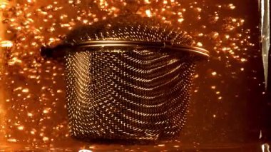 Sıcak suda çay demlemek için süzgeç. 1000 fps 'de yüksek hızlı bir kamerayla çekildi. Yüksek kaliteli FullHD görüntüler