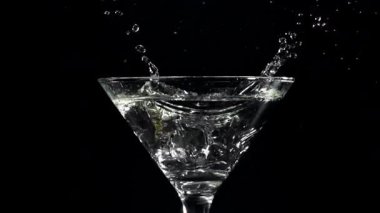 Buz, martini bardağına düşer. 1000 fps 'de yüksek hızlı bir kamerayla çekildi. Yüksek kaliteli FullHD görüntüler