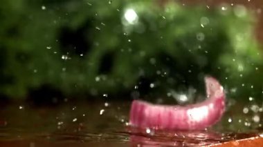 Doğranmış soğan kesme tahtasına düşer. 1000 fps 'de yüksek hızlı bir kamerayla çekildi. Yüksek kaliteli FullHD görüntüler