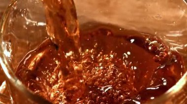 Siyah çay fincana dökülür. 1000 fps 'de yüksek hızlı bir kamerayla çekildi. Yüksek kaliteli FullHD görüntüler