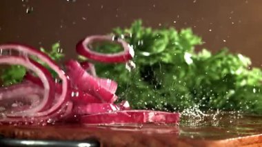 Doğranmış soğan kesme tahtasına düşer. 1000 fps 'de yüksek hızlı bir kamerayla çekildi. Yüksek kaliteli FullHD görüntüler