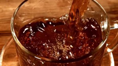 Siyah çay fincana dökülür. 1000 fps 'de yüksek hızlı bir kamerayla çekildi. Yüksek kaliteli FullHD görüntüler