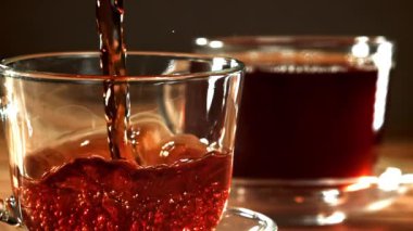 Siyah çay fincana dökülür. 1000 fps 'de yüksek hızlı bir kamerayla çekildi. Yüksek kaliteli FullHD görüntüler