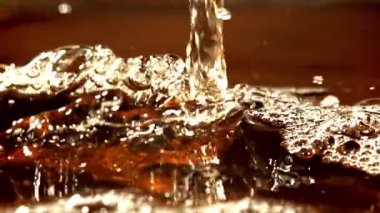 Siyah çay serpintileri. 1000 fps 'de yüksek hızlı bir kamerayla çekildi. Yüksek kaliteli FullHD görüntüler
