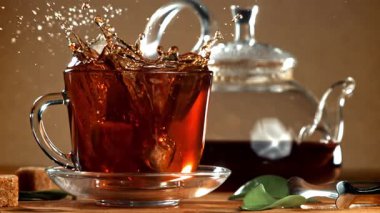 Bir parça şeker bir fincan siyah çaya düşer. 1000 fps 'de yüksek hızlı bir kamerayla çekildi. Yüksek kaliteli FullHD görüntüler