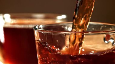 Siyah çay fincana dökülür. 1000 fps 'de yüksek hızlı bir kamerayla çekildi. Yüksek kaliteli FullHD görüntüler