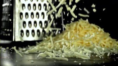 Rendelenmiş peynir masaya düşer. 1000 fps 'de yüksek hızlı bir kamerayla çekildi. Yüksek kaliteli FullHD görüntüler