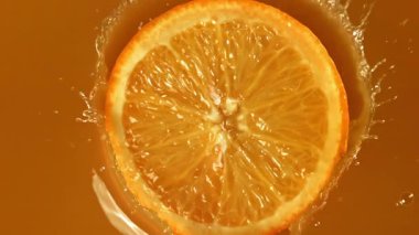 Meyve suyuna bir dilim portakal düşer. 1000 fps 'de yüksek hızlı bir kamerayla çekildi. Yüksek kaliteli FullHD görüntüler