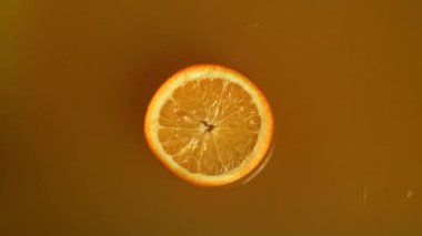 Meyve suyuna bir dilim portakal düşer. 1000 fps 'de yüksek hızlı bir kamerayla çekildi. Yüksek kaliteli FullHD görüntüler