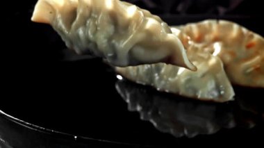 Geleneksel gyoze köfteleri soya sosuna dökülüyor. 1000 fps 'de yüksek hızlı bir kamerayla çekildi. Yüksek kaliteli FullHD görüntüler