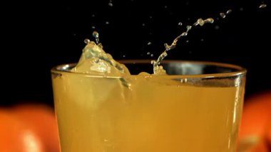 Buz küpleri portakal suyuna düşer. 1000 fps 'de yüksek hızlı bir kamerayla çekildi. Yüksek kaliteli FullHD görüntüler