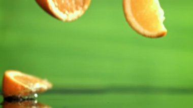 Dilimlenmiş portakal dilimleri masaya düşer. 1000 fps 'de yüksek hızlı bir kamerayla çekildi. Yüksek kaliteli FullHD görüntüler
