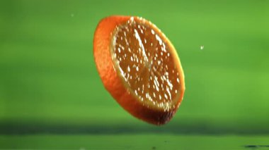 Dilimlenmiş portakal dilimleri masaya düşer. 1000 fps 'de yüksek hızlı bir kamerayla çekildi. Yüksek kaliteli FullHD görüntüler