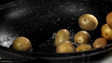 Patatesler büyük bir kızartma tavasında kızartılıyor. 1000 fps 'de yüksek hızlı bir kamerayla çekildi. Yüksek kaliteli FullHD görüntüler