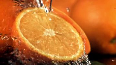Su portakalın yarısına dökülür. 1000 fps 'de yüksek hızlı bir kamerayla çekildi. Yüksek kaliteli FullHD görüntüler