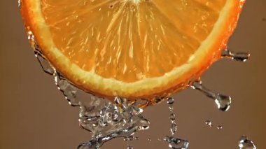 Yuvarlak bir portakal diliminden su akar. 1000 fps 'de yüksek hızlı bir kamerayla çekildi. Yüksek kaliteli FullHD görüntüler