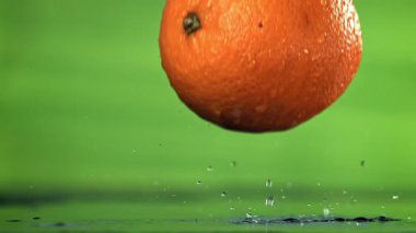 Bir portakal ıslak masaya düşer. 1000 fps 'de yüksek hızlı bir kamerayla çekildi. Yüksek kaliteli FullHD görüntüler