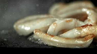 Mürekkep balığı halkaları tavada kızarır. 1000 fps 'de yüksek hızlı bir kamerayla çekildi. Yüksek kaliteli FullHD görüntüler