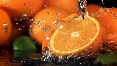 Su portakalın yarısına dökülür. 1000 fps 'de yüksek hızlı bir kamerayla çekildi. Yüksek kaliteli FullHD görüntüler