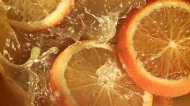Portakal dilimleri portakal suyuna düşer. 1000 fps 'de yüksek hızlı bir kamerayla çekildi. Yüksek kaliteli FullHD görüntüler