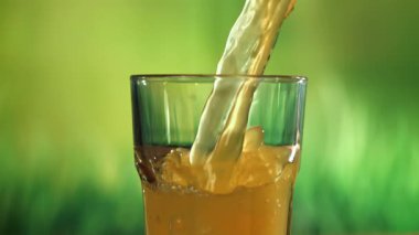 Portakal suyu bardağa dökülür. 1000 fps 'de yüksek hızlı bir kamerayla çekildi. Yüksek kaliteli FullHD görüntüler