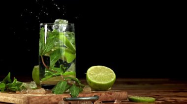 Buz mojito kokteyline düşer. 1000 fps 'de yüksek hızlı bir kamerayla çekildi. Yüksek kaliteli FullHD görüntüler