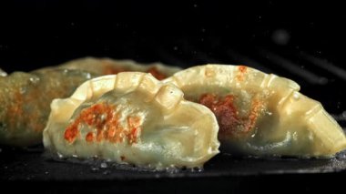 Geleneksel gyoze köfteleri tavada kızartılır. 1000 fps 'de yüksek hızlı bir kamerayla çekildi. Yüksek kaliteli FullHD görüntüler