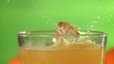 Buz küpleri portakal suyuna düşer. 1000 fps 'de yüksek hızlı bir kamerayla çekildi. Yüksek kaliteli FullHD görüntüler