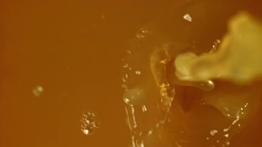 Portakal suyu damlatıyor. 1000 fps 'de yüksek hızlı bir kamerayla çekildi. Yüksek kaliteli FullHD görüntüler