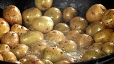 Patatesler büyük bir kızartma tavasında kızartılıyor. 1000 fps 'de yüksek hızlı bir kamerayla çekildi. Yüksek kaliteli FullHD görüntüler