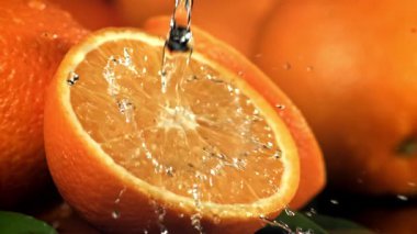 Su portakalın yarısına dökülür. 1000 fps 'de yüksek hızlı bir kamerayla çekildi. Yüksek kaliteli FullHD görüntüler
