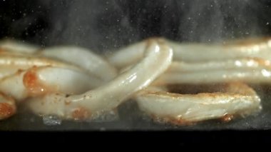 Mürekkep balığı halkaları tavada kızarır. 1000 fps 'de yüksek hızlı bir kamerayla çekildi. Yüksek kaliteli FullHD görüntüler