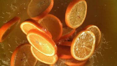 Portakal dilimleri portakal suyuna düşer. 1000 fps 'de yüksek hızlı bir kamerayla çekildi. Yüksek kaliteli FullHD görüntüler
