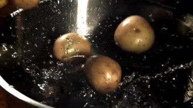 Patatesler tencereye düşer. 1000 fps 'de yüksek hızlı bir kamerayla çekildi. Yüksek kaliteli FullHD görüntüler