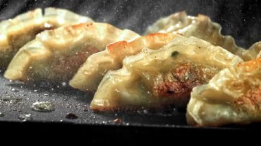 Geleneksel gyoze köfteleri tavada kızartılır. 1000 fps 'de yüksek hızlı bir kamerayla çekildi. Yüksek kaliteli FullHD görüntüler