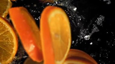 Dilimlenmiş turuncu daireler suya düşer. 1000 fps 'de yüksek hızlı bir kamerayla çekildi. Yüksek kaliteli FullHD görüntüler