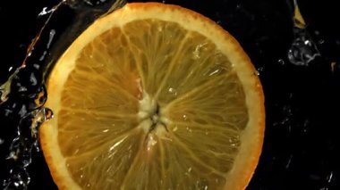 Dilimlenmiş bir portakal çemberi suya düşer. 1000 fps 'de yüksek hızlı bir kamerayla çekildi. Yüksek kaliteli FullHD görüntüler