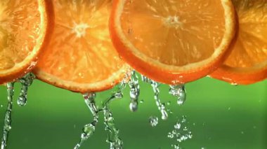 Dilimlenmiş portakallardan su damlıyor. 1000 fps 'de yüksek hızlı bir kamerayla çekildi. Yüksek kaliteli FullHD görüntüler