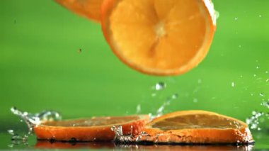 Dilimlenmiş portakal dilimleri masaya düşer. 1000 fps 'de yüksek hızlı bir kamerayla çekildi. Yüksek kaliteli FullHD görüntüler