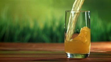 Portakal suyu bardağa dökülür. 1000 fps 'de yüksek hızlı bir kamerayla çekildi. Yüksek kaliteli FullHD görüntüler