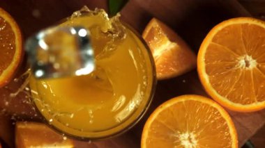 Buz küpleri portakal suyuna düşer. 1000 fps 'de yüksek hızlı bir kamerayla çekildi. Yüksek kaliteli FullHD görüntüler