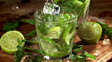 Buz mojito kokteyline düşer. 1000 fps 'de yüksek hızlı bir kamerayla çekildi. Yüksek kaliteli FullHD görüntüler