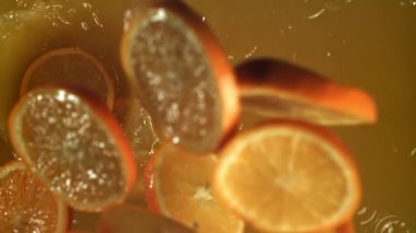 Portakal dilimleri portakal suyuna düşer. 1000 fps 'de yüksek hızlı bir kamerayla çekildi. Yüksek kaliteli FullHD görüntüler