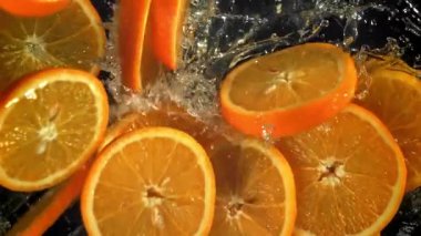 Dilimlenmiş turuncu daireler suya düşer. 1000 fps 'de yüksek hızlı bir kamerayla çekildi. Yüksek kaliteli FullHD görüntüler